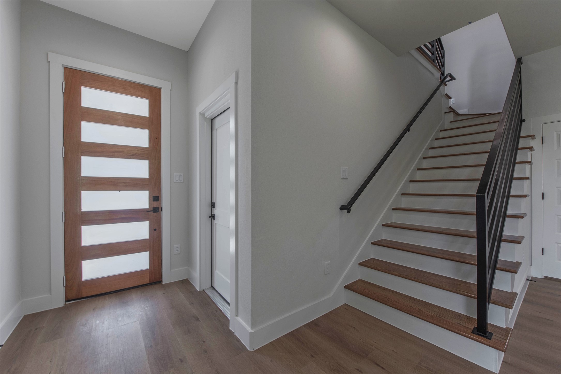 9311 Jutland Road Houston, TX 77033 - Photo 5 of 28 The door to the right leads to a spacious garage with ample room for parking and storage. Glass inserts in the modern front door invite natural light.