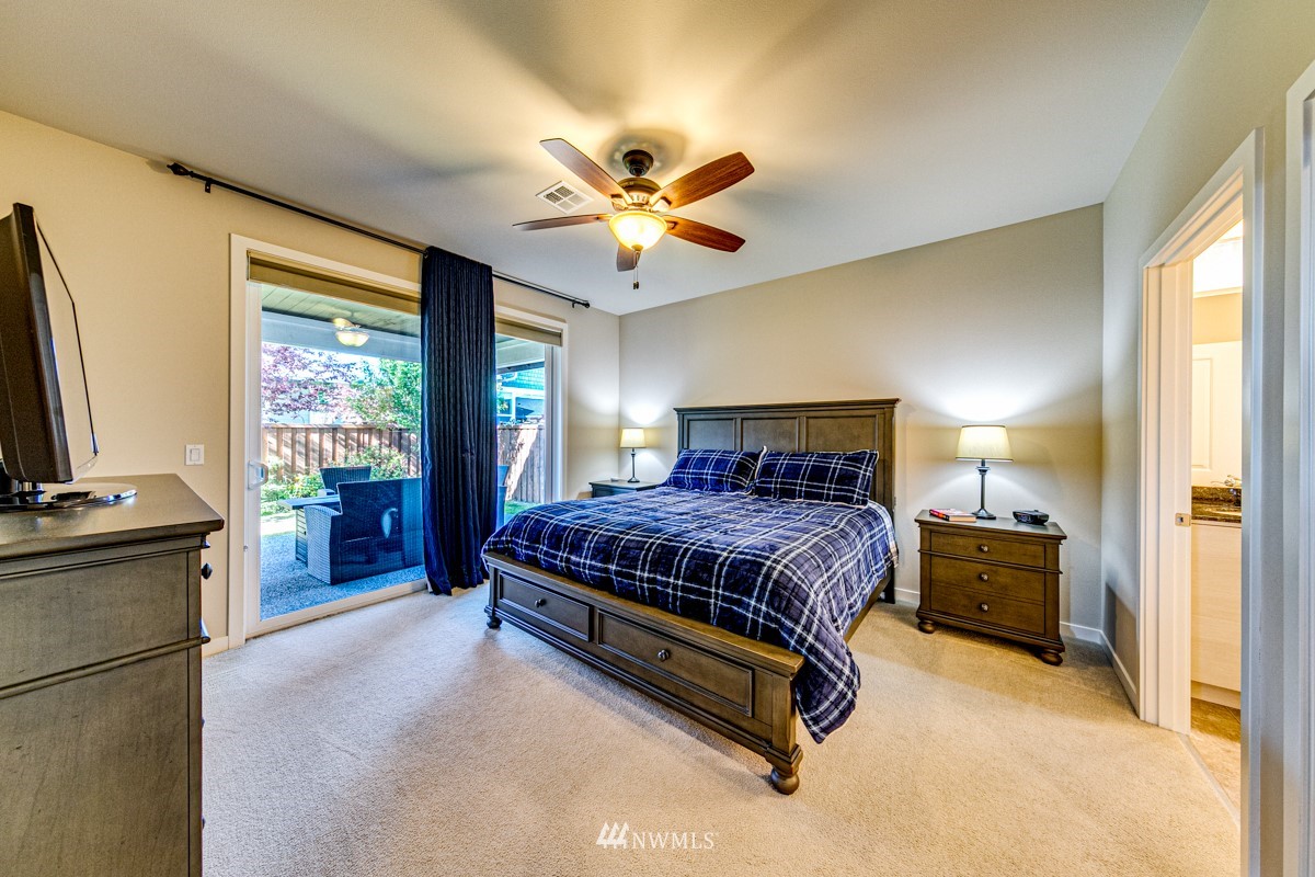 431 Lofgrin Road Sequim, WA 98382 - Photo 22 of 35 a spacious bedroom with a bed and a chandelier