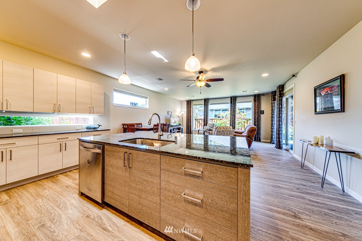 431 Lofgrin Road Sequim, WA 98382 - Photo 8 of 35 a kitchen with kitchen island granite countertop a sink cabinets and wooden floor