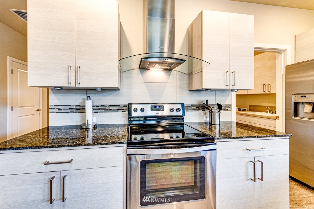431 Lofgrin Road Sequim, WA 98382 - Photo 10 of 35 a kitchen with stainless steel appliances granite countertop a stove a sink and a white cabinets