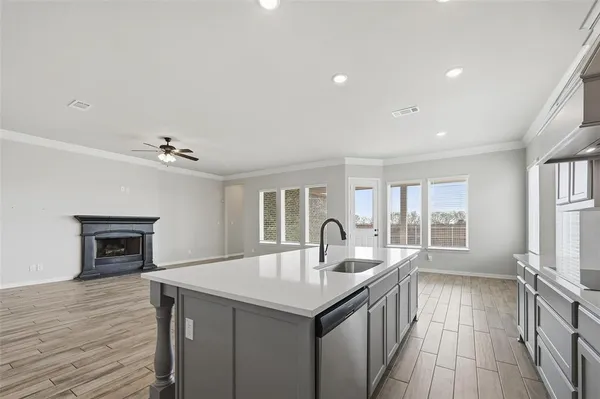 a kitchen with kitchen island a sink appliances and a fireplace