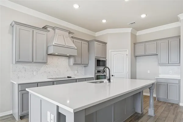 a kitchen with white cabinets a sink and dishwasher