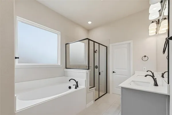a bathroom with a tub a sink and mirror