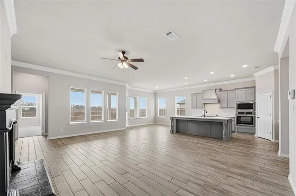 a view of empty room with wooden floor and window