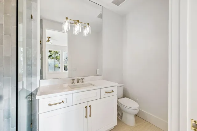 a bathroom with a granite countertop sink toilet and shower