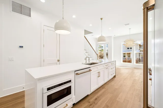 a view of an empty room with wooden floor and a fireplace