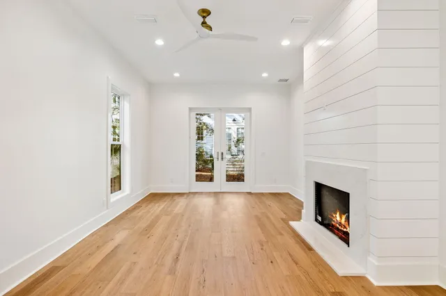 a view of an empty room with a window and wooden floor