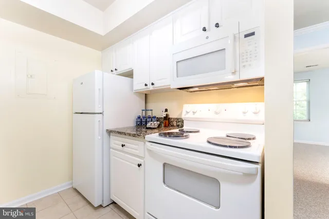 a kitchen with stainless steel appliances white cabinets and a refrigerator