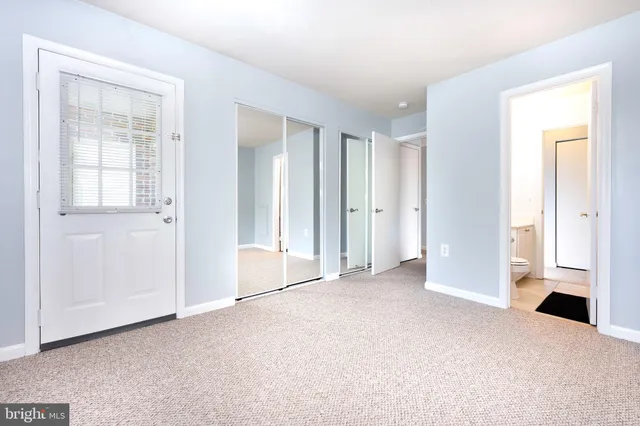 an empty room with windows and closet