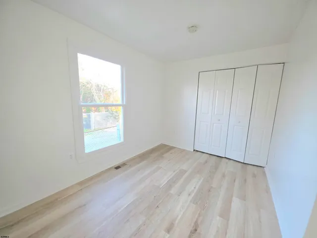 a view of an empty room and wooden floor