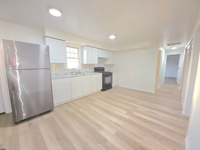 a kitchen with granite countertop white cabinets and stainless steel appliances