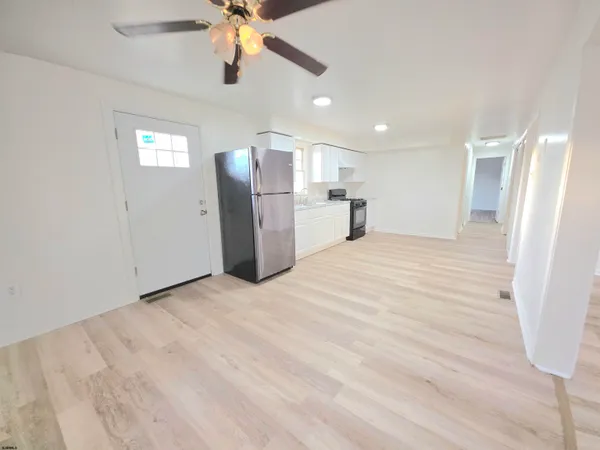 a view of a kitchen with a sink and a refrigerator