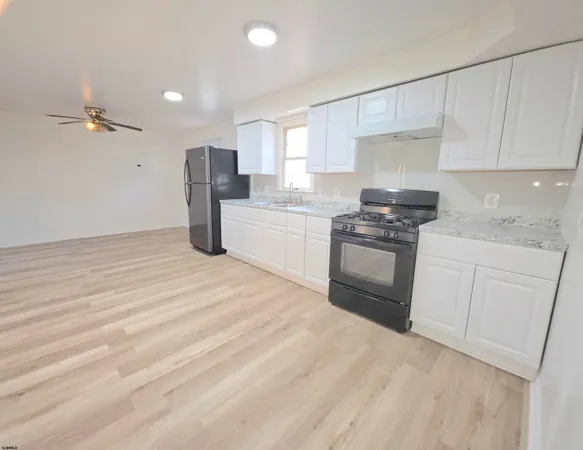 a kitchen with granite countertop white cabinets and stainless steel appliances