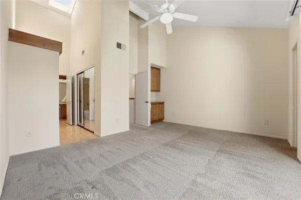 en empty room with an entryway and chandelier fan