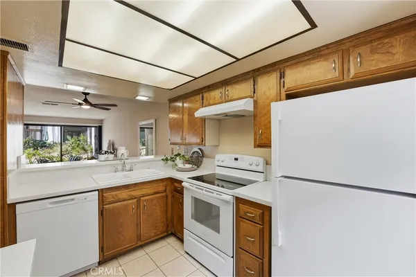 a kitchen with stainless steel appliances granite countertop a sink and a refrigerator