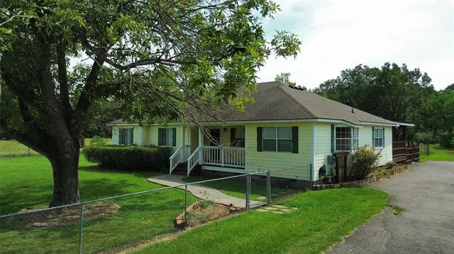 a aerial view of a house with yard and green space