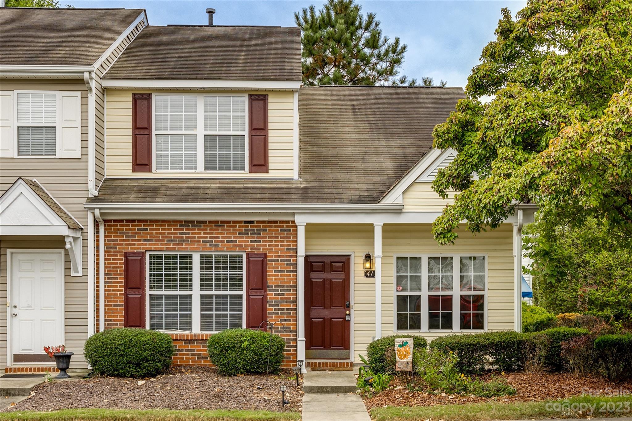 front view of a brick house with a yard