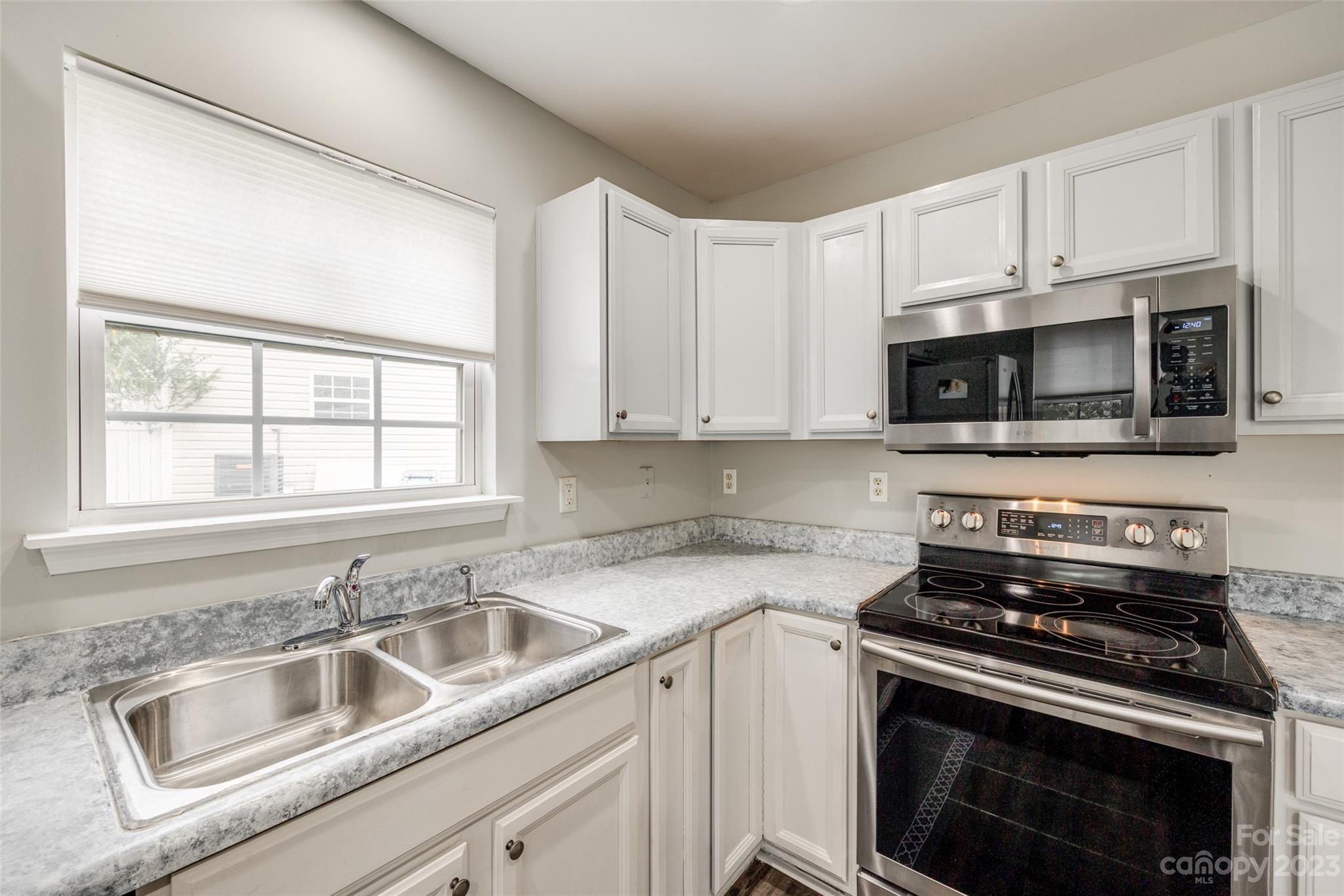 413 Caddy Street Fort Mill, SC 29715 - Photo 8 of 26 a kitchen with granite countertop a sink stove and microwave