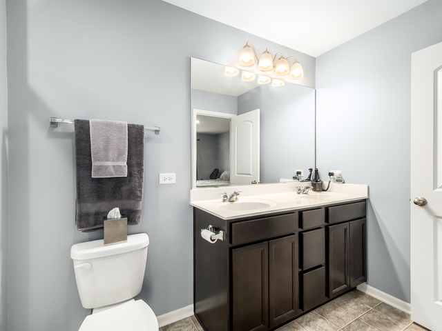 2421 Upland Road Pingree Grove, IL 60140 - Photo 13 of 21 a bathroom with a toilet sink and mirror
