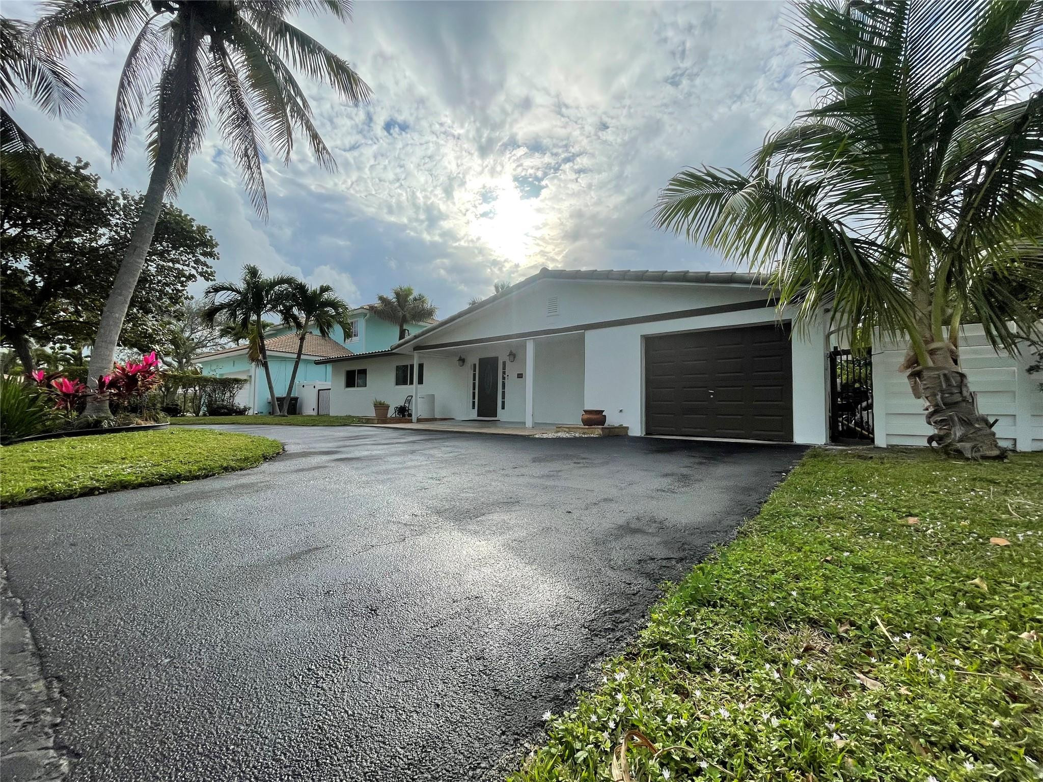 3231 Northeast 27th Terrace Lighthouse Point, FL 33064 - Photo 1 of 30 a view of a house with a yard and palm trees