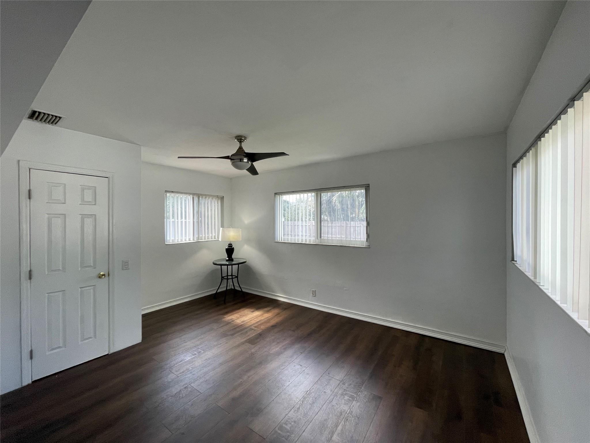 3231 Northeast 27th Terrace Lighthouse Point, FL 33064 - Photo 11 of 30 a view of empty room with wooden floor and fan