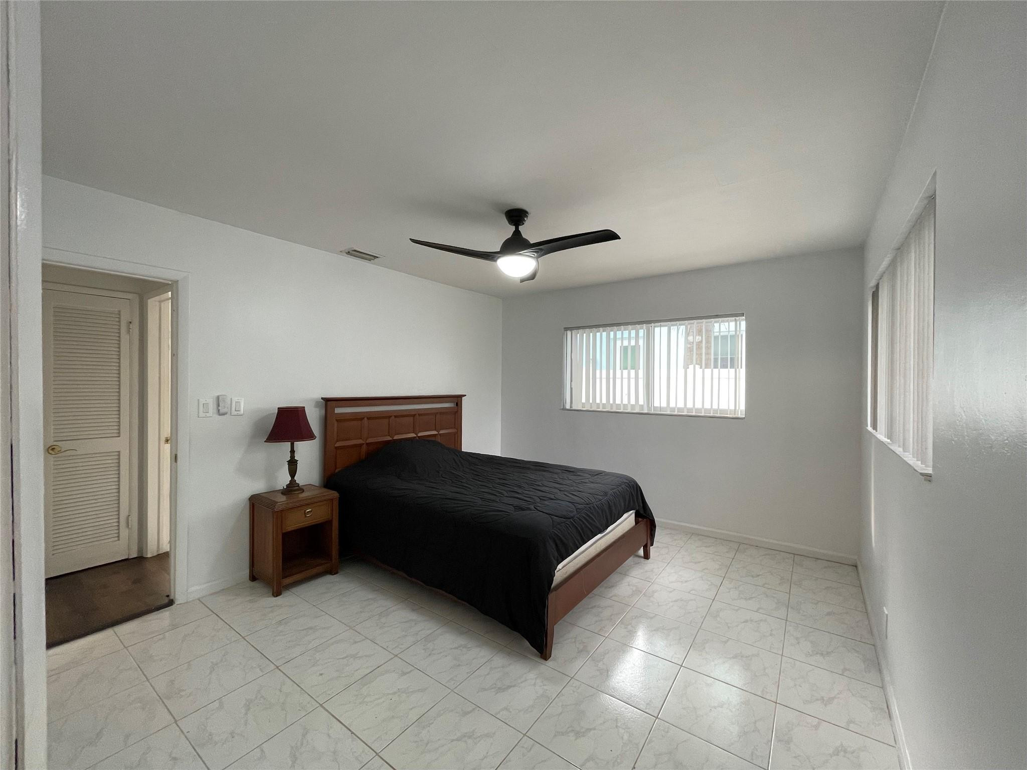 3231 Northeast 27th Terrace Lighthouse Point, FL 33064 - Photo 14 of 30 a spacious bedroom with a bed and window