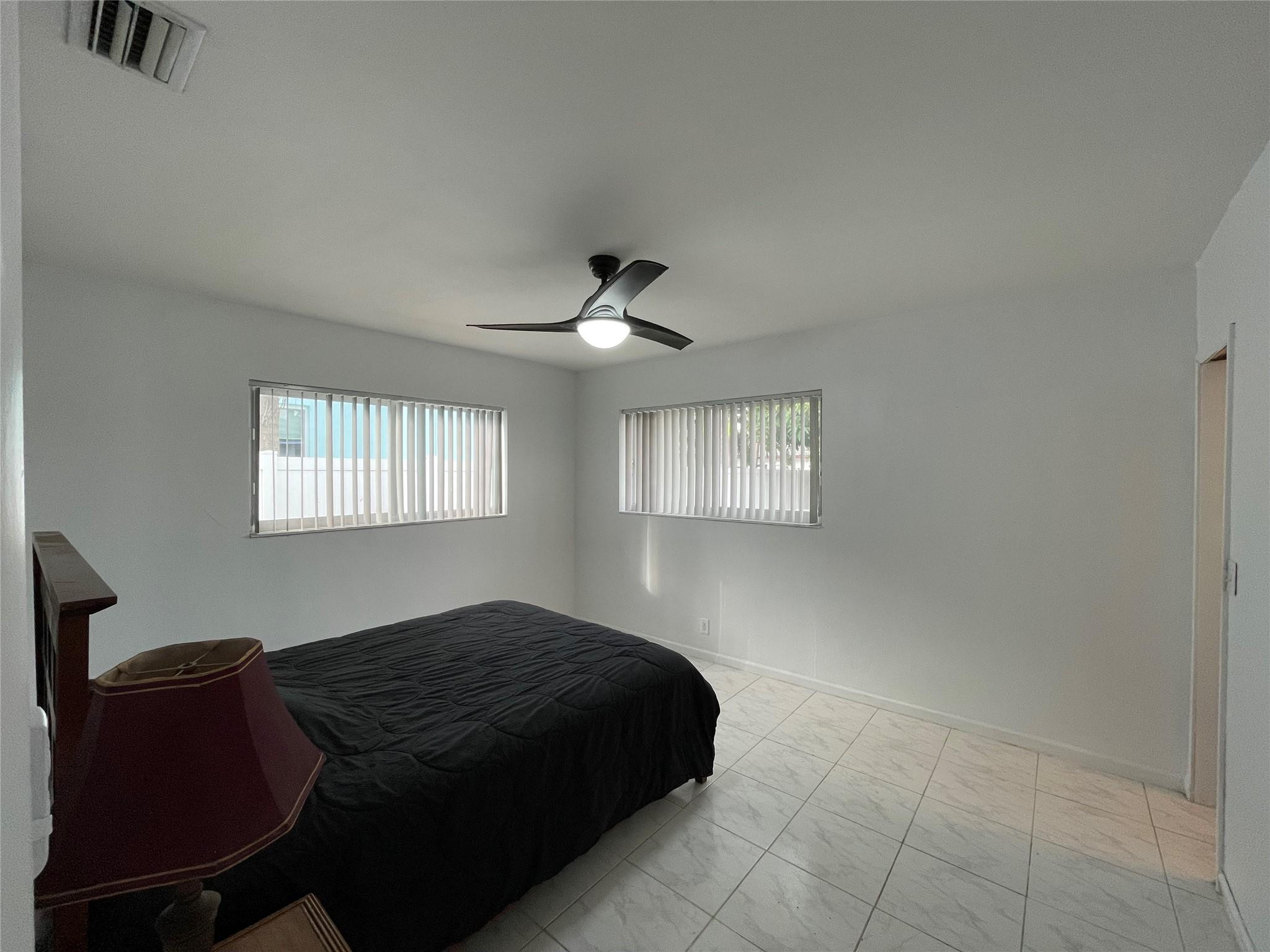 3231 Northeast 27th Terrace Lighthouse Point, FL 33064 - Photo 15 of 30 a bedroom with a bed and a chair