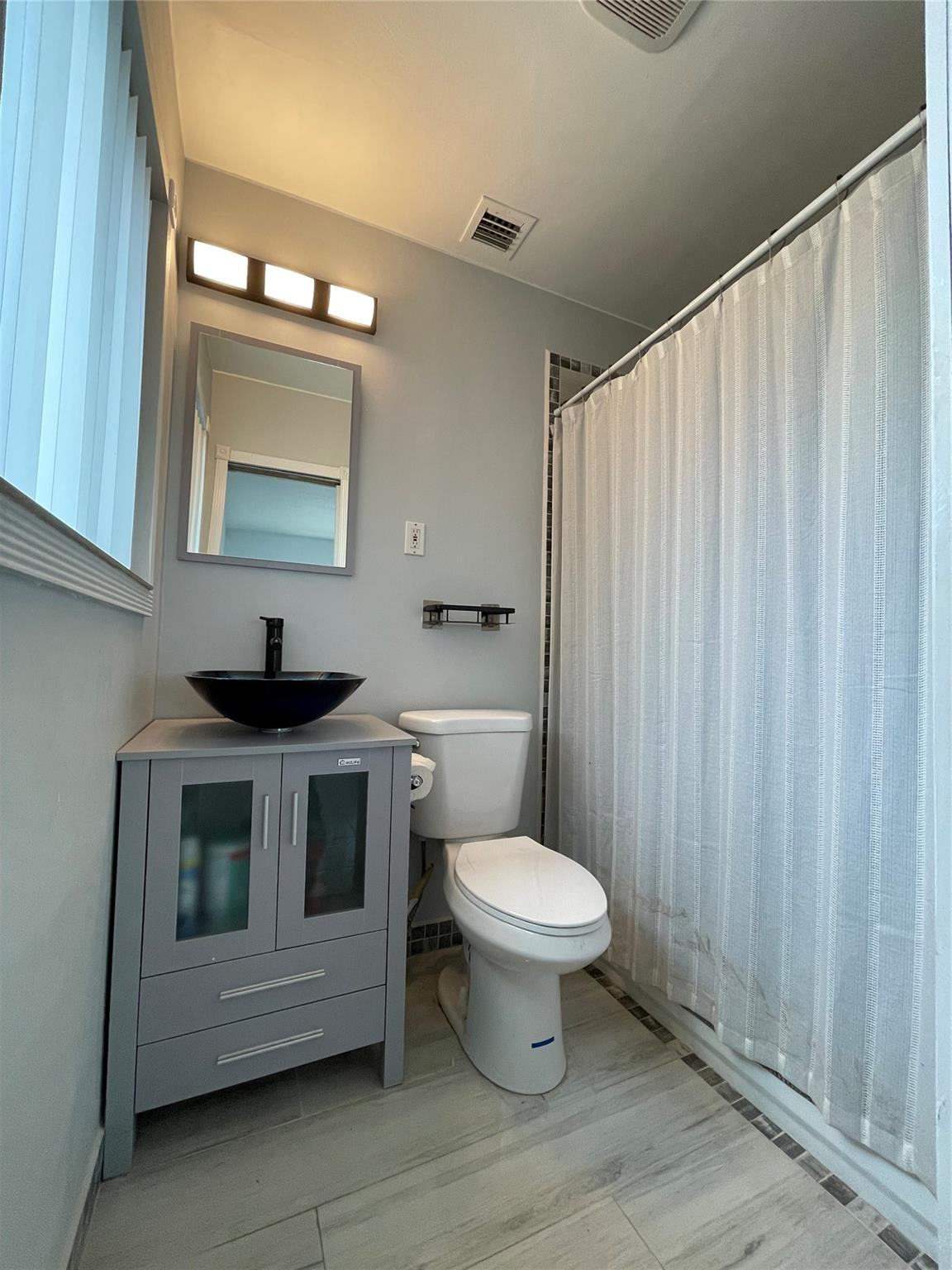 3231 Northeast 27th Terrace Lighthouse Point, FL 33064 - Photo 16 of 30 a bathroom with a toilet a sink and a mirror