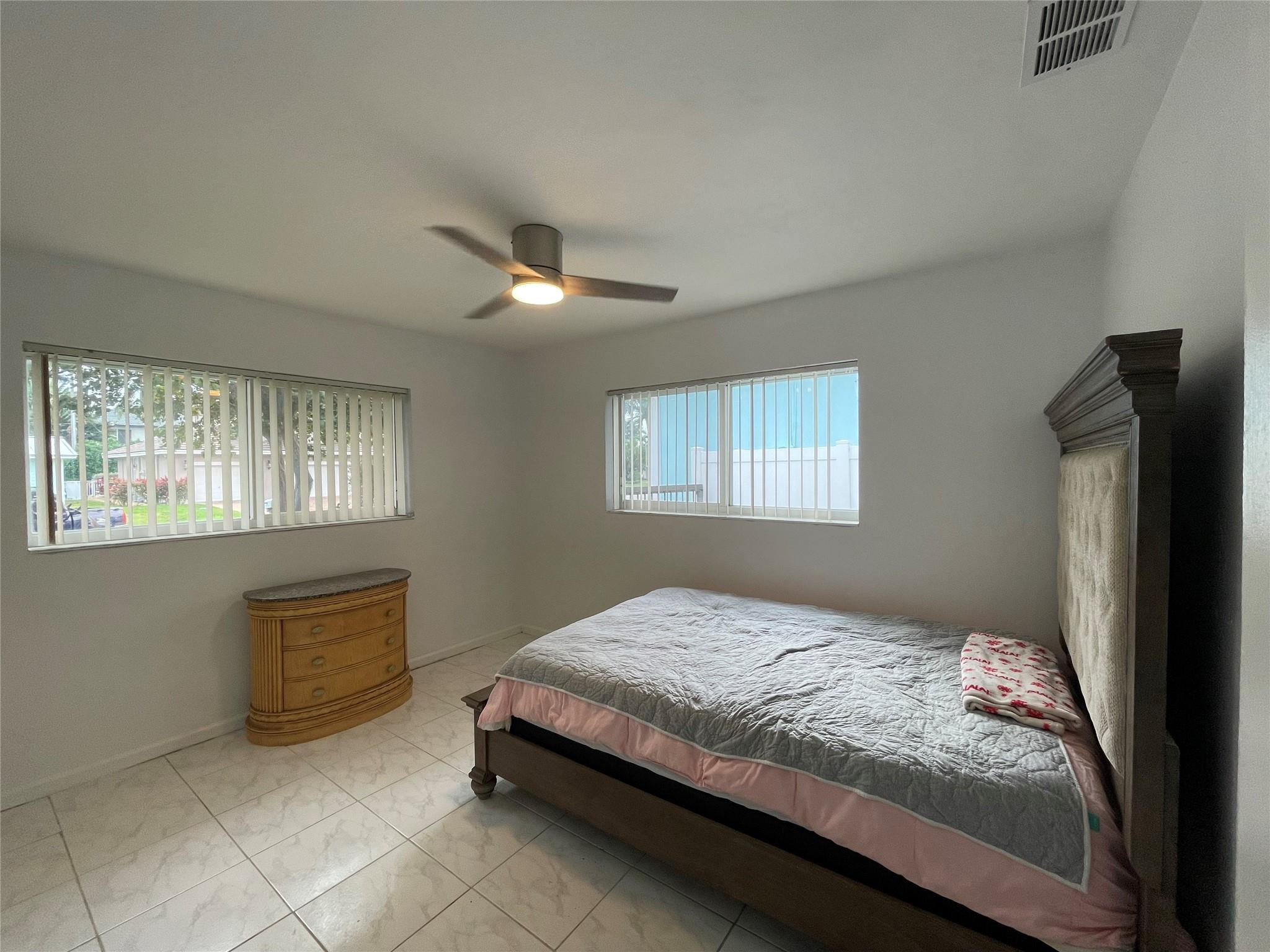 3231 Northeast 27th Terrace Lighthouse Point, FL 33064 - Photo 17 of 30 a bedroom with a bed and a window