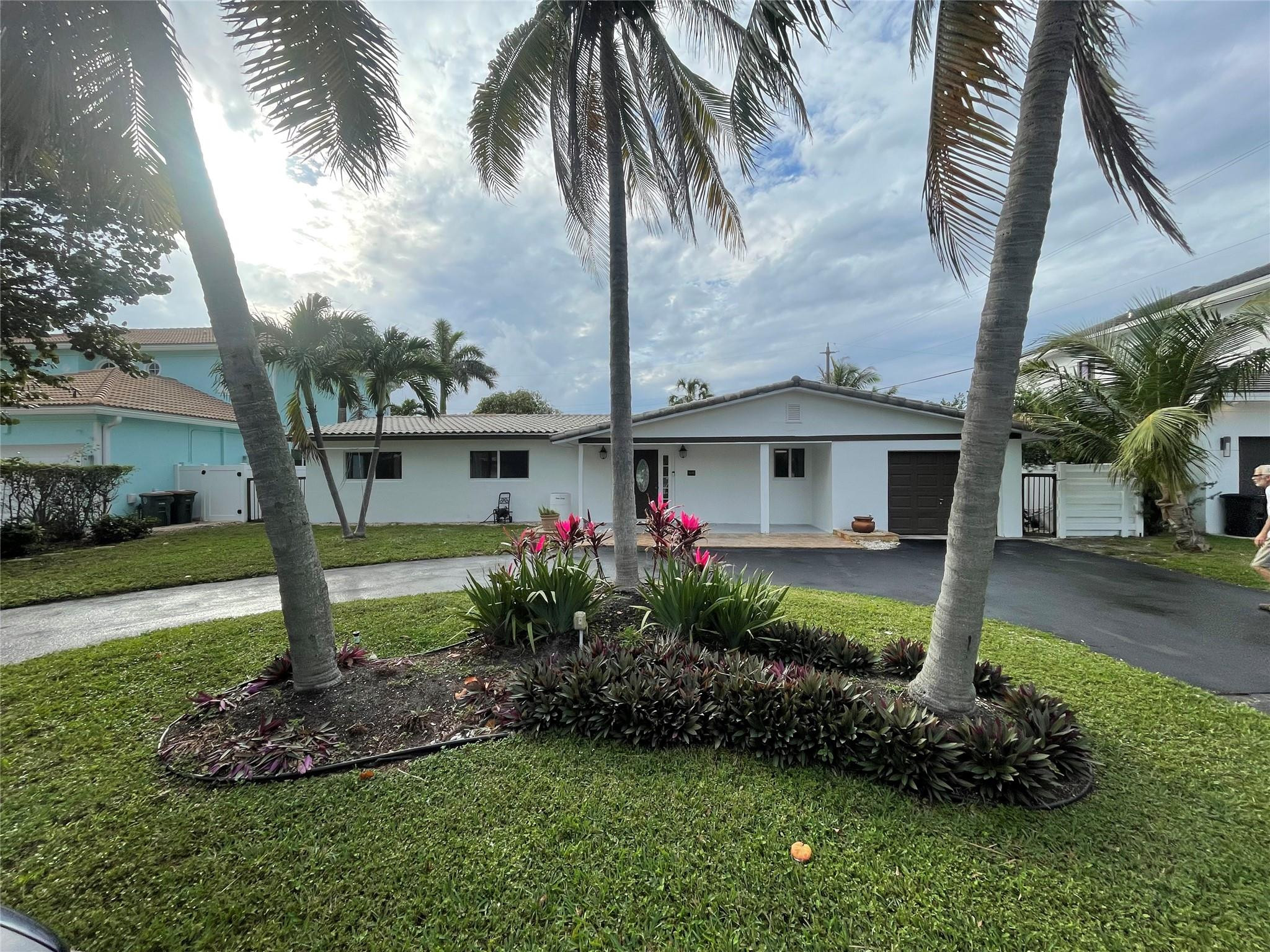 3231 Northeast 27th Terrace Lighthouse Point, FL 33064 - Photo 2 of 30 a front view of a house with garden