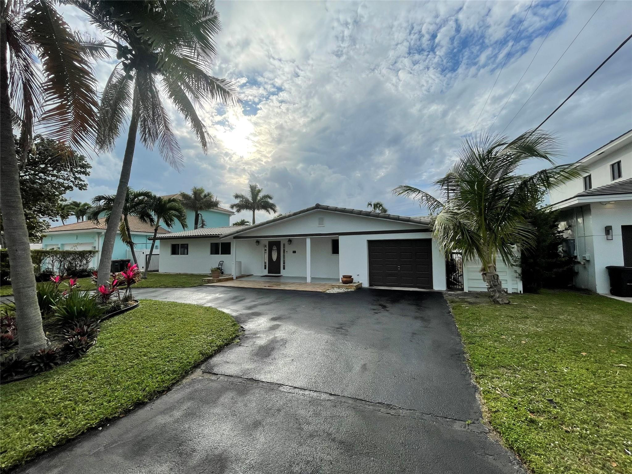 3231 Northeast 27th Terrace Lighthouse Point, FL 33064 - Photo 6 of 30 a front view of house with yard and green space