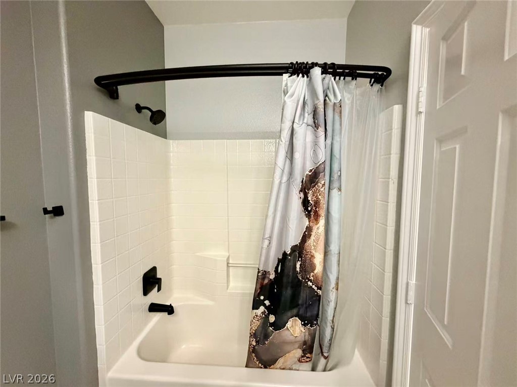 135 Tall Ruff Drive Las Vegas, NV 89148 - Photo 8 of 29 A pristine white tiled shower/tub combination awaits, ready for daily rejuvenation.