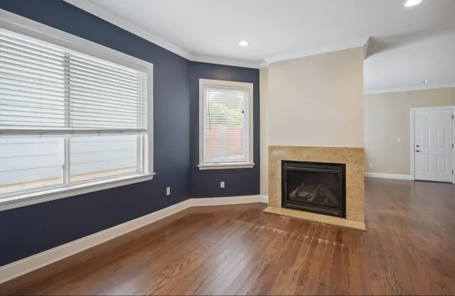 wooden floor fireplace and windows in an empty room