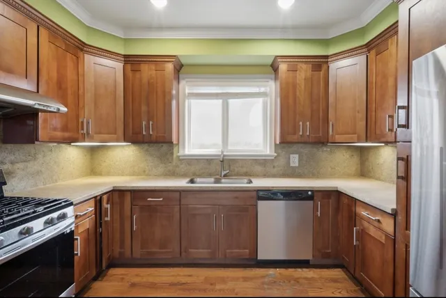 a kitchen with stainless steel appliances granite countertop a sink and a stove