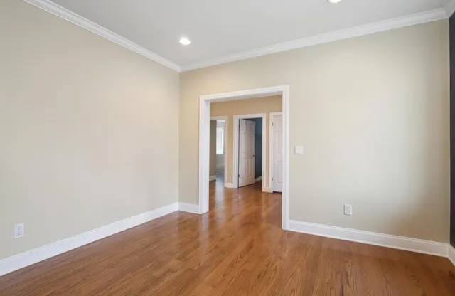an empty room with wooden floor and closet