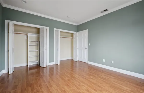 a view of an empty room with wooden floor
