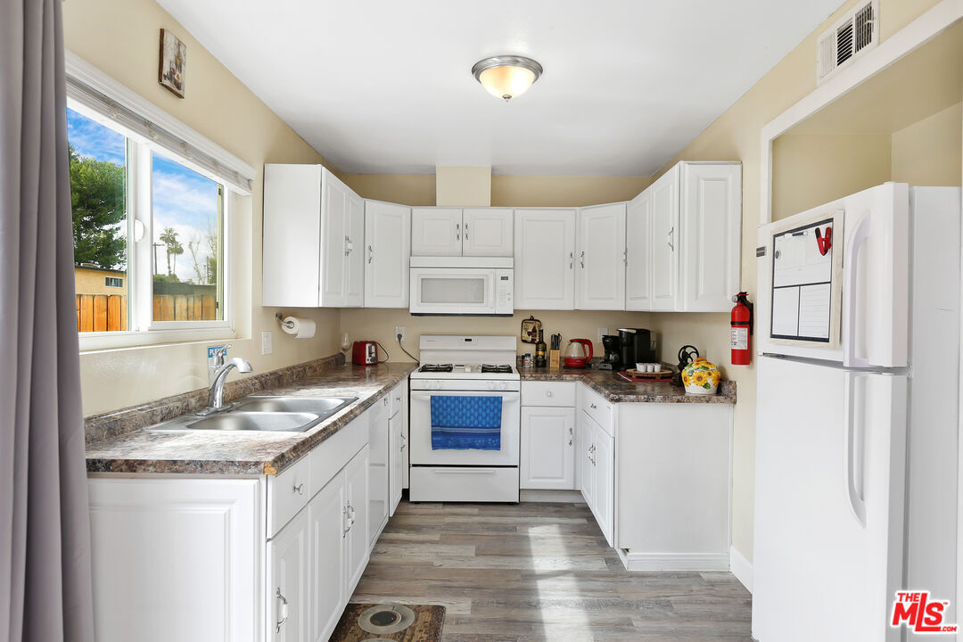 3519 Polk Street Riverside, CA 92505 - Photo 7 of 28 a kitchen with granite countertop a sink stove refrigerator and cabinets
