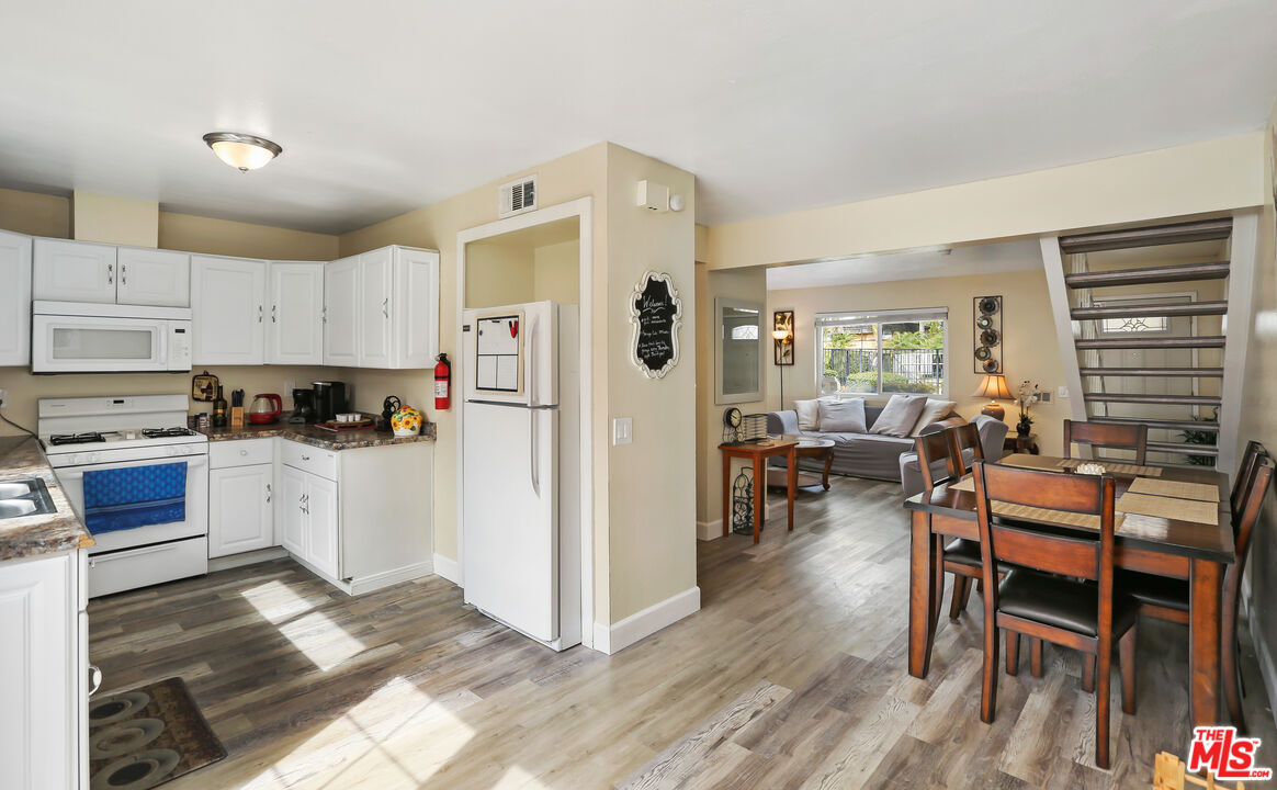 3519 Polk Street Riverside, CA 92505 - Photo 10 of 28 a kitchen with stainless steel appliances a refrigerator a stove a dining table and chairs with wooden floor