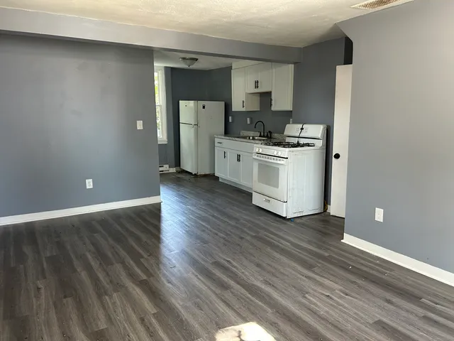 a kitchen with wooden floors and white appliances