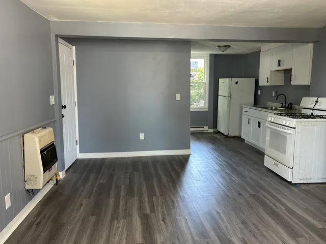 a kitchen with wooden floors and white cabinets