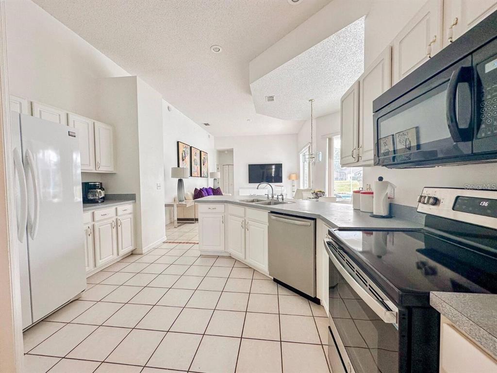 344 Grosvenor Loop Davenport, FL 33897 - Photo 8 of 27 a kitchen with a sink cabinets and stainless steel appliances