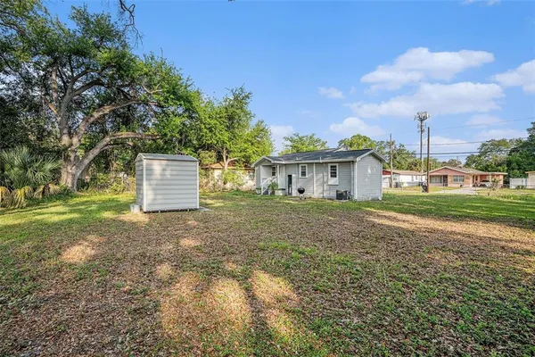 a view of a house with backyard and trees