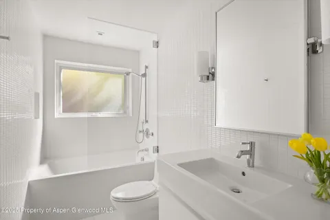 a bedroom with two beds and a large window