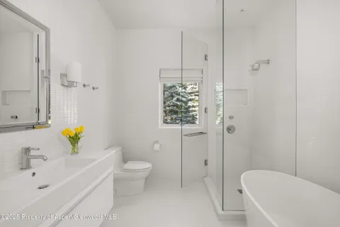 a bedroom with a large bed and a flat tv screen