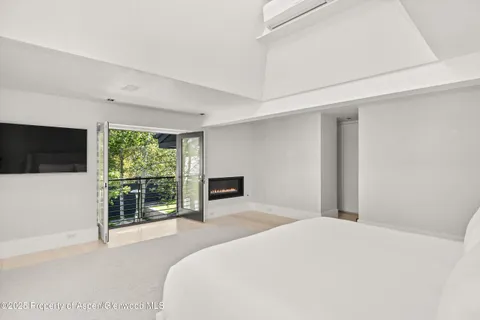 a living room with a bed and a flat screen tv