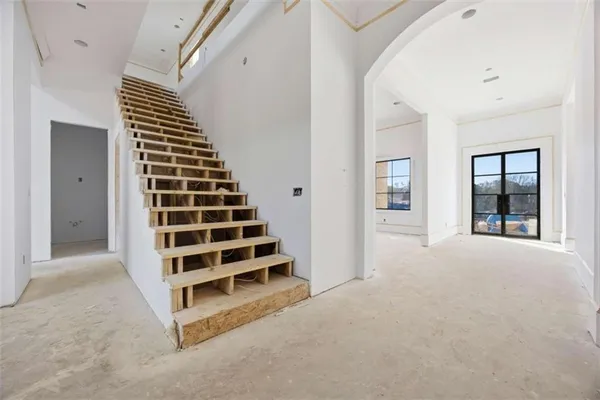 a view of an empty room with wooden floor and windows