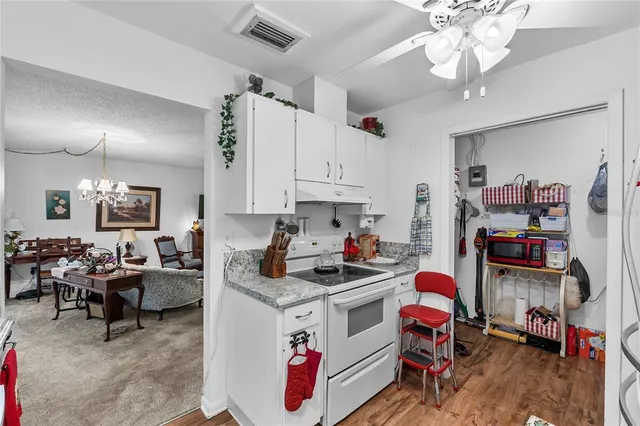a kitchen that has a lot of cabinets appliances and a dining table
