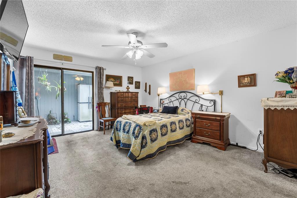 6642 Trail Ridge Drive, Unit 6642 Lakeland, FL 33813 - Photo 18 of 39 a spacious bedroom with a bed and a chandelier