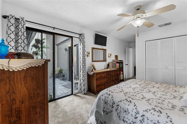 a bedroom with a bed dresser and a large window