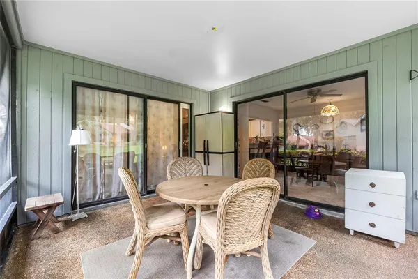 a dining room with furniture water view and a floor to ceiling window